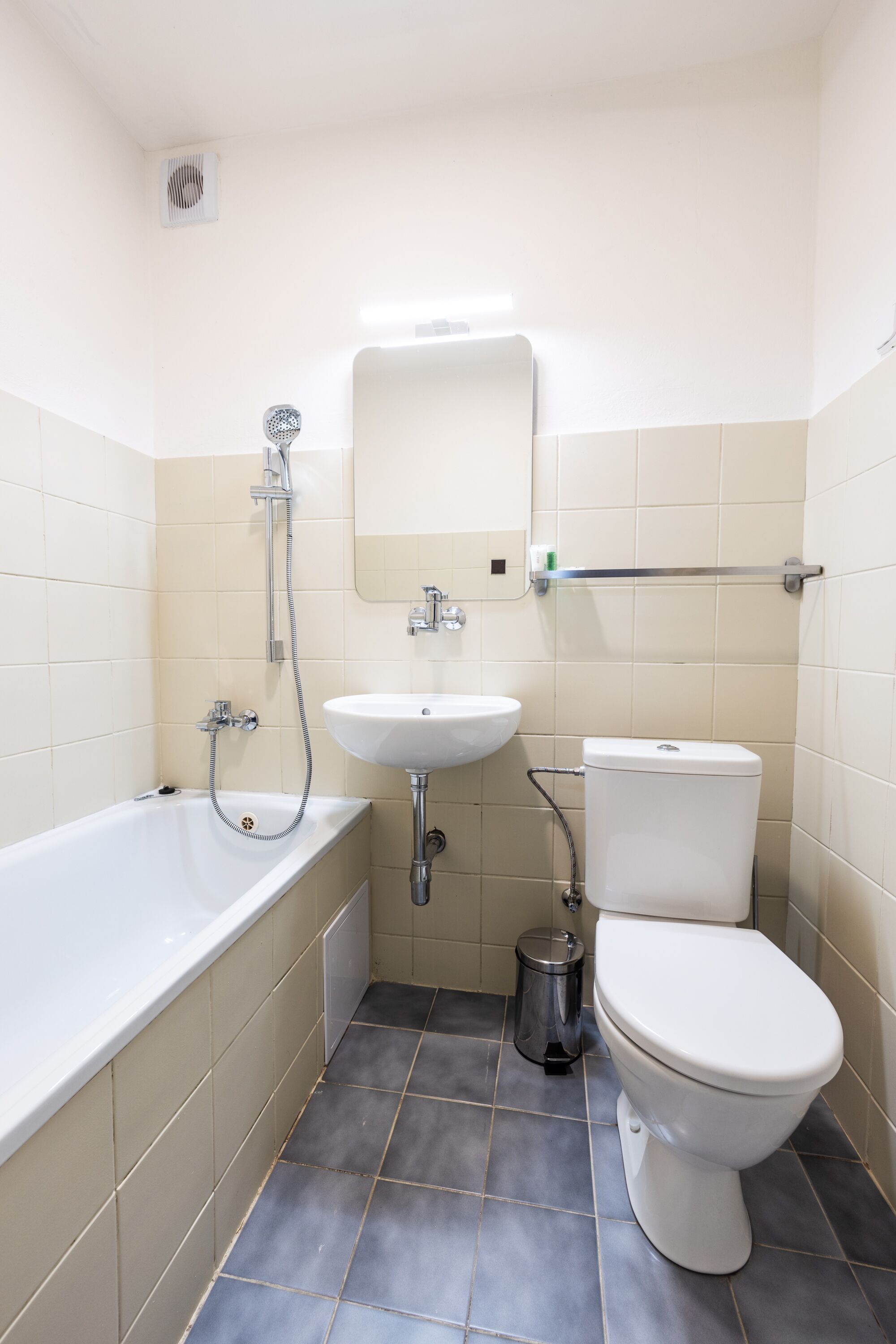 A bathroom with a bathtub, sink, toilet, and a mirror.