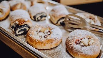 A tray of pastries, including a variety of filled and dusted doughnuts.