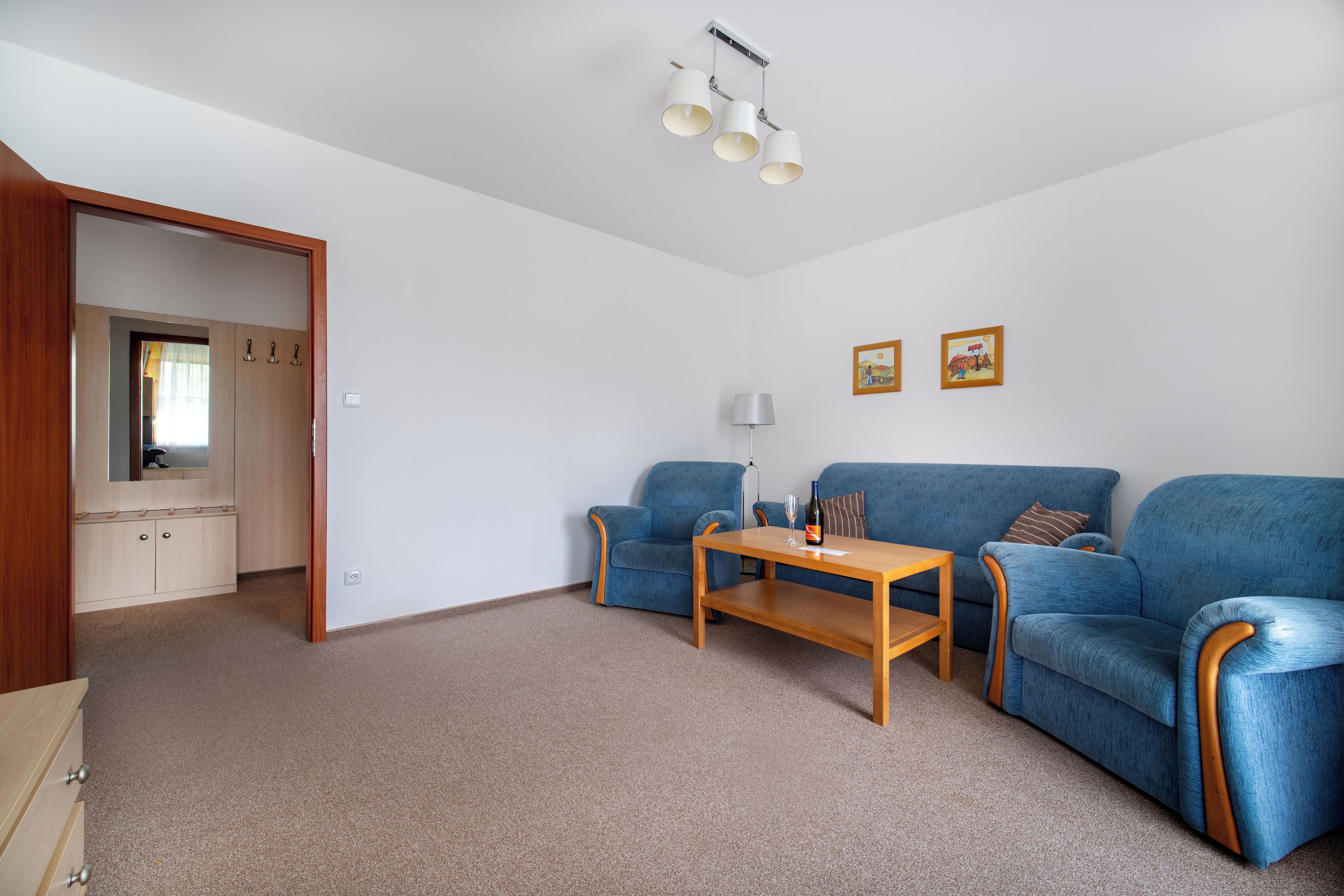 Ein modernes Wohnzimmer mit einer Sofagarnitur, einem Holztisch und einer Lampe.