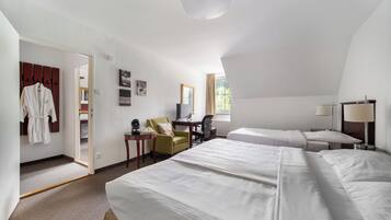 Habitación de hotel con dos camas, un escritorio, una silla, un armario y una ventana con cortinas.