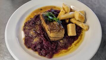 Um prato de comida com carne, repolho roxo e batatas fritas.