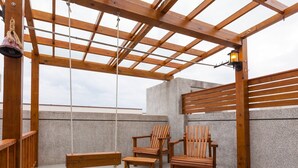 A wooden deck with a swing, two wooden chairs, and a bench. - Professor's House 2198 (Ji'an)