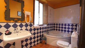 Un baño con lavamanos, inodoro, bañera y espejo.