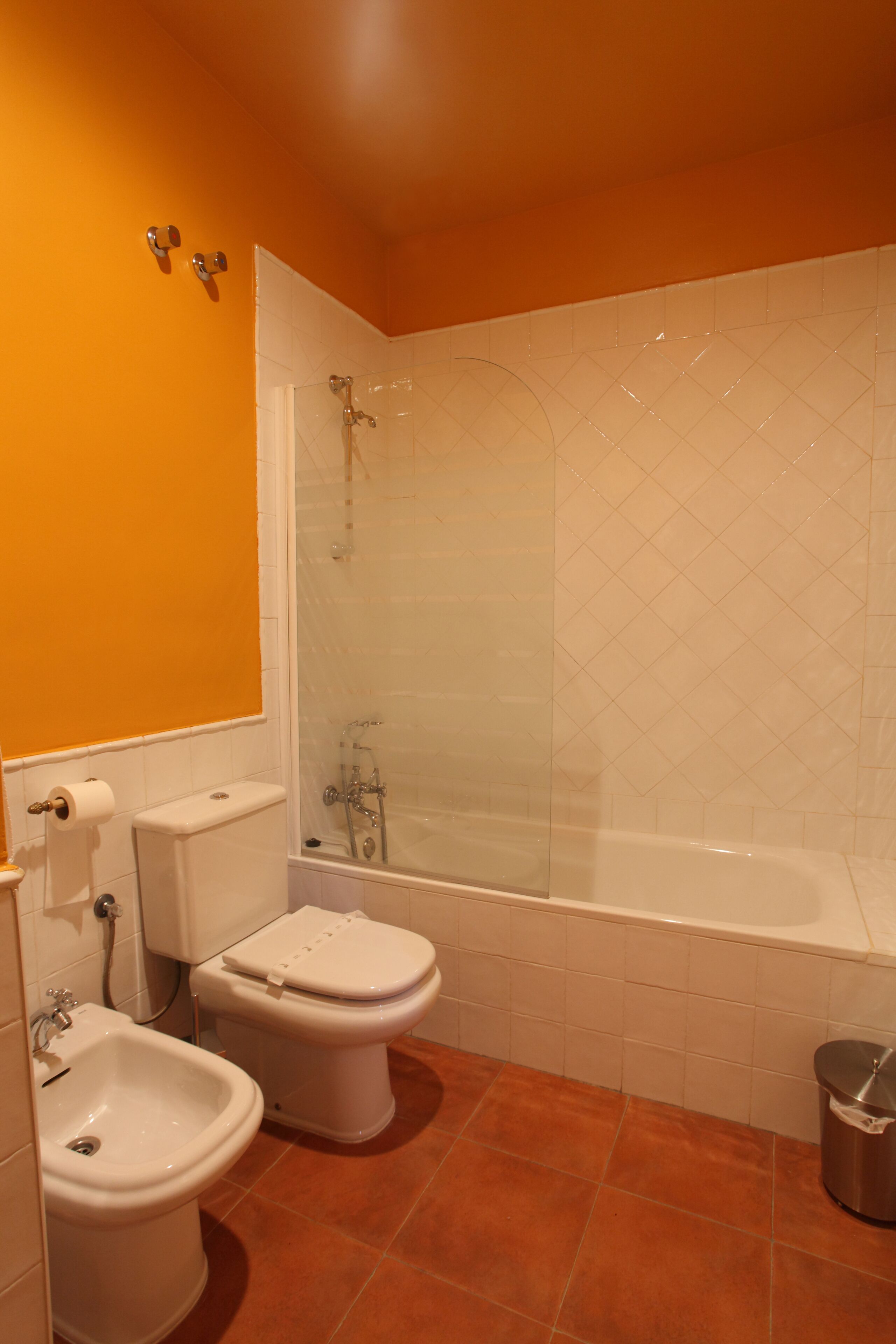 A bathroom with a toilet, bidet, and bathtub.