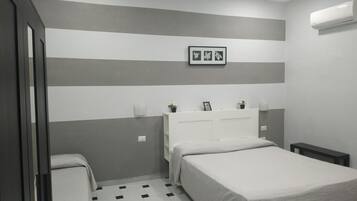 Ein Schlafzimmer mit einem Bett, Nachttischen, einem Kleiderschrank und einem Schachbrettmuster-Boden.