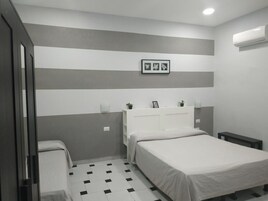 Een slaapkamer met een bed, nachtkastjes, een garderobe en een geruit vloerkleed.