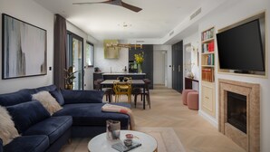 Una sala de estar moderna con un sofá azul oscuro, una mesa de centro y una chimenea.