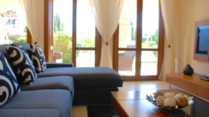 Ein modernes Wohnzimmer mit einer Couch, einem Couchtisch und einem Fernseher.
