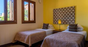 A room with two beds, a window, a wall with a polka dot pattern, and a lamp. - Villa TD02 TV - Arethusa (Kouklia)