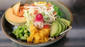 A bowl of salad with various vegetables and fruits.