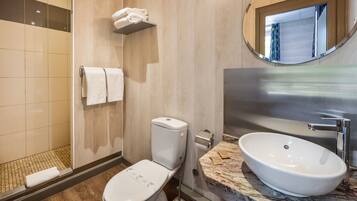 Une salle de bain moderne équipée de toilettes, d’un lavabo et d’une douche.