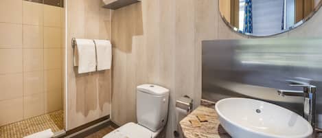 A modern bathroom with a toilet, sink, and shower.
