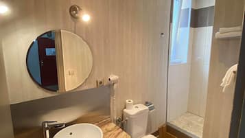 A modern bathroom with a marble sink, a toilet, and a shower area.