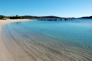 A beach with clear water, sandy shore, and distant hills. - 1 Sea View Apartment 70m from the beach (Lecci)