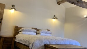 A bedroom with a wooden bed, two bedside tables, and a bench.