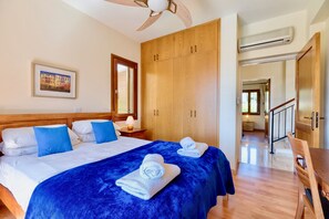 Habitación de hotel con una cama grande, un armario de madera y vistas al pasillo.
