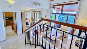 A spacious living area with a staircase, a dining area, and a kitchen. - Villa 98 - Helidoni (Kouklia)