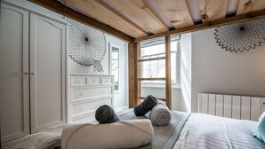 A bedroom with a bed, a white dresser, and a window with a view. - Lady Tenby - 2 Bedroom Luxury Apartment (Tenby)