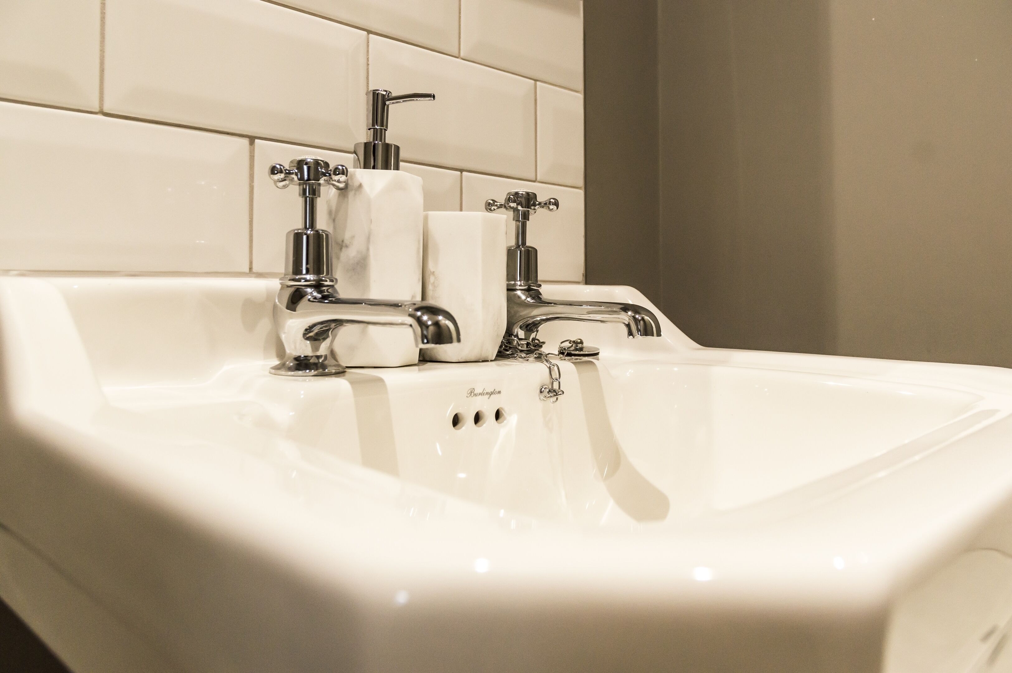A white bathroom sink with a single faucet and a paper towel dispenser.