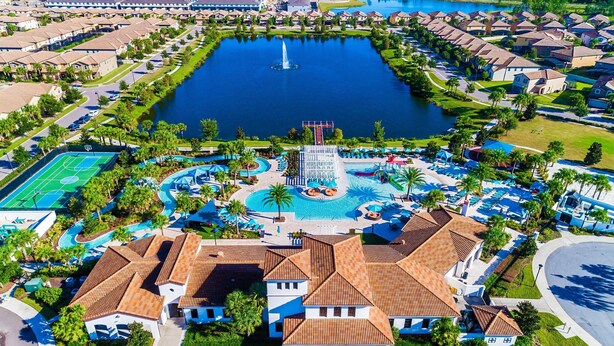 An aerial view of a residential area with a central swimming pool, tennis courts, and a fountain. - Fascinating 5 BR Home Near Disney 8931 (Kissimmee)