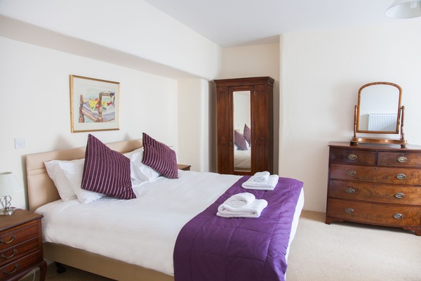 Escritorio, cortinas blackout y tabla de planchar con plancha