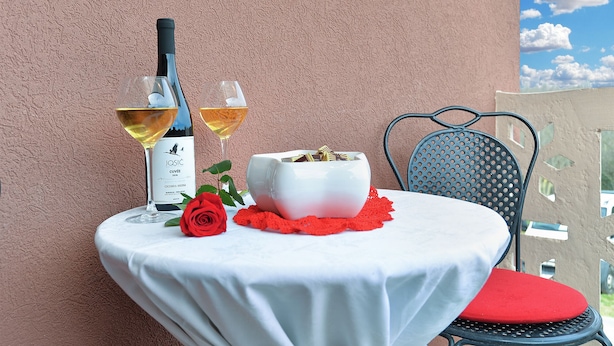 A table with a white tablecloth, a white bowl, a red rose, and two wine glasses on a balcony. - Apartment 2018/28685 (Istria - Pula), 2500m from the beach (Pula)
