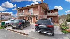 A two-story house with a balcony and a garage with two cars parked. - Apartment 2018/28685 (Istria - Pula), 2500m from the beach (Pula)