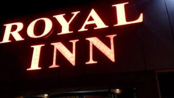 The exterior of the Royal Inn with illuminated signage.