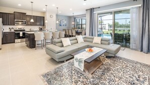 Een moderne woonkamer met een hoekbank, een salontafel en een eethoek met stoelen.