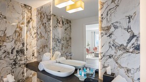 A modern bathroom with marble walls, a dual sink vanity, and a large mirror. - Monastero dei Santi (Rome)