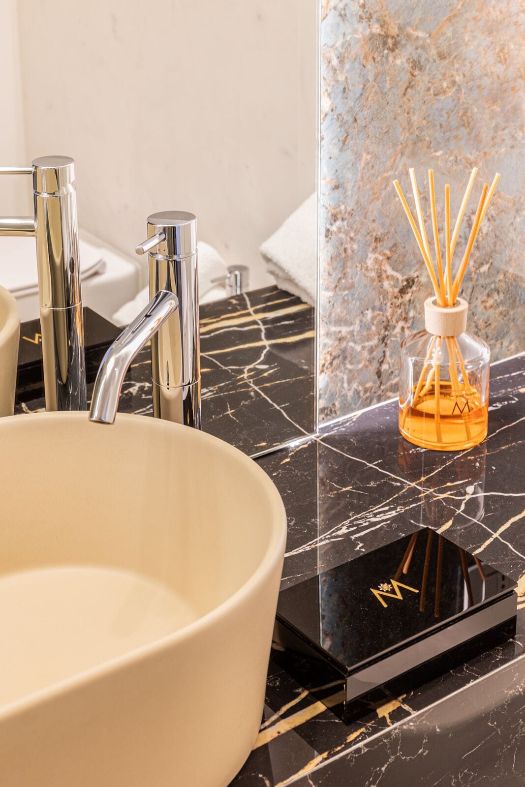 Ein modernes Badezimmer mit einem weißen Keramikbecken, Chromarmaturen und einer Marmorarbeitsplatte.