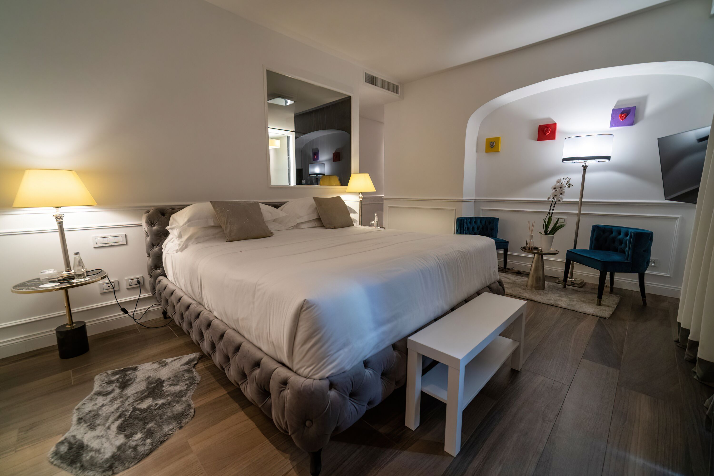 Une chambre d’hôtel moderne, dotée d’un grand lit, de tables de chevet, d’un bureau et d  ’une chaise.