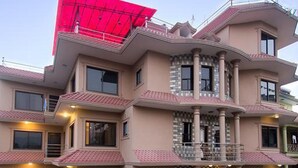 A multi-story building with balconies, a flat roof, and a gated entrance. - Rinchen Hotel (Kathmandu)