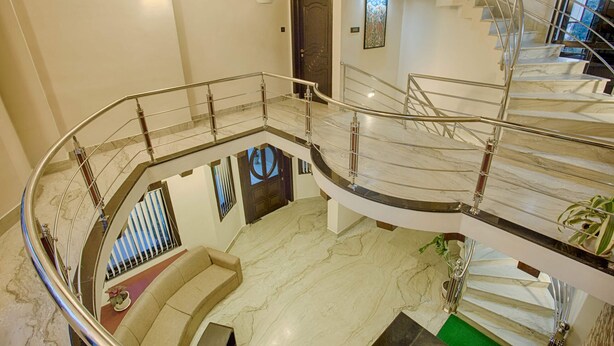 A multi-level interior with a curved staircase, marble flooring, and a seating area. - Rinchen Hotel (Kathmandu)