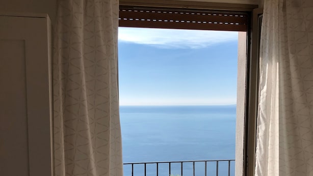 A balcony with a view of the sea, featuring two white metal tables and a potted plant. - Villa Jole Taormina (Taormina)