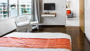A hotel room with a bed, a TV, a chair, and a view of the city. - SEACRAZE D702 - 1 Bedroom - Near Beach (Hua Hin)