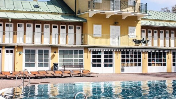 A building with a swimming pool, a clock tower, and a statue on the roof. - MOTEL Bad Vöslau (Bad Voeslau)