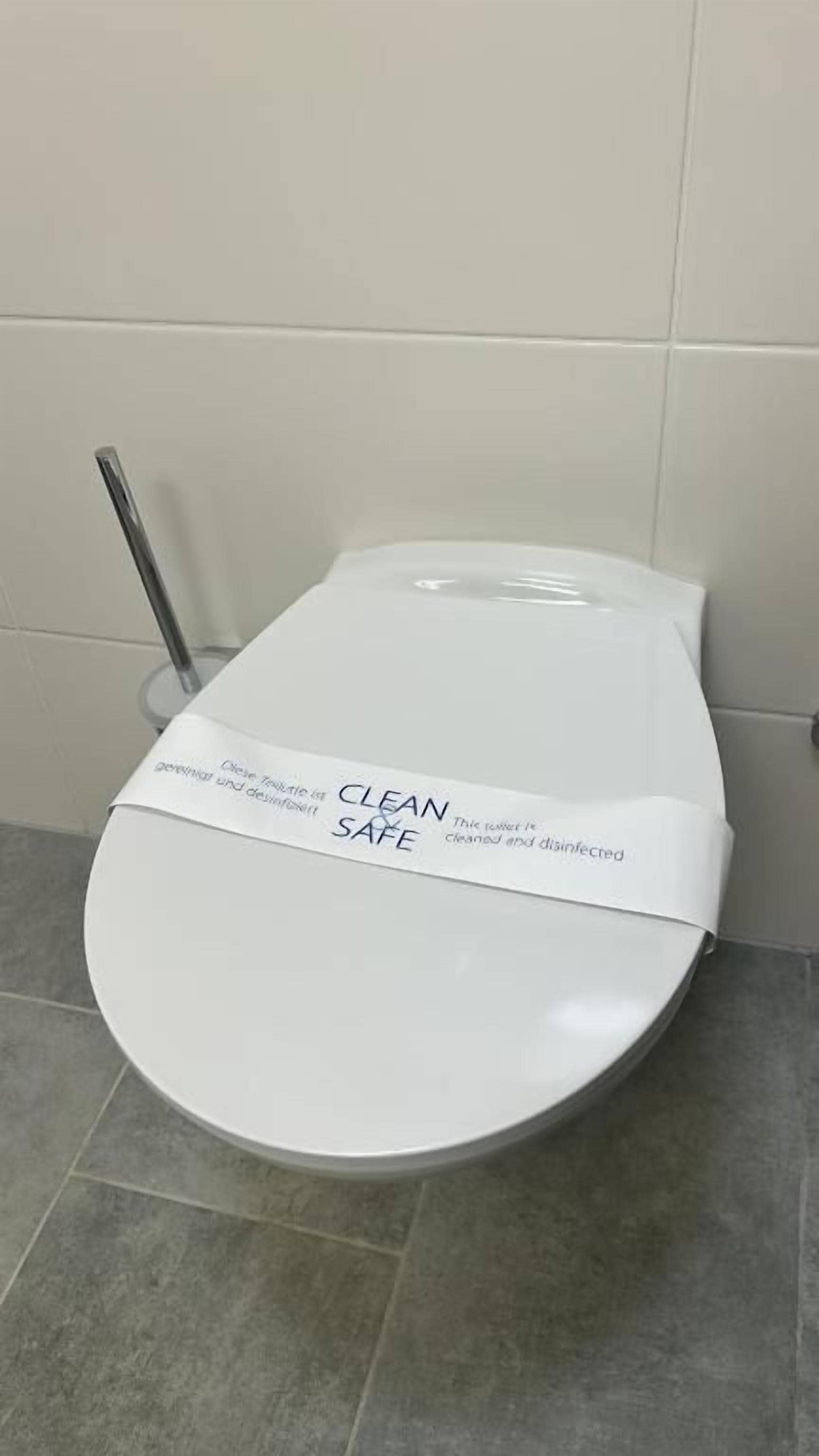 Un inodoro con tapa blanca y una etiqueta que dice 'CLEAN SAFE'.