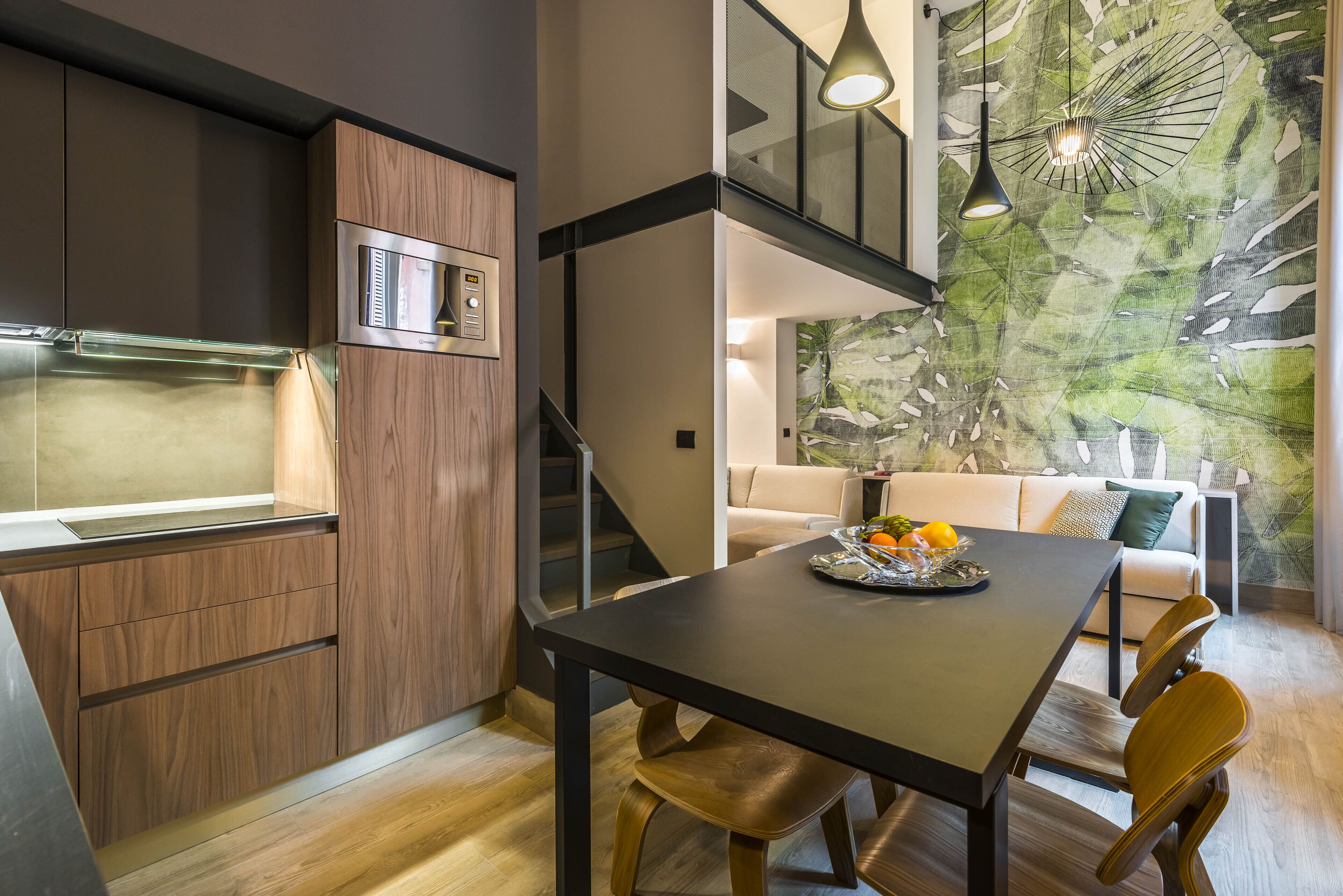 Una cucina moderna con forno a microonde integrato, mobili in legno e un'area pranzo con tavolo e sedie.