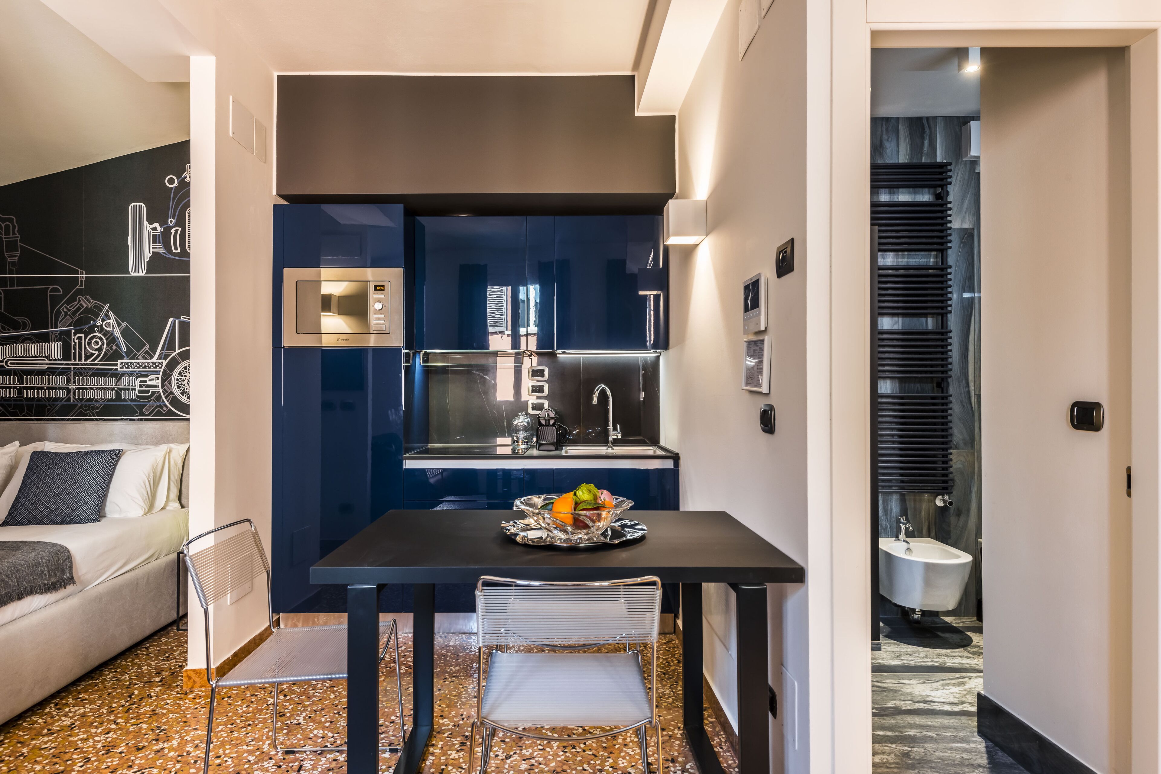 A compact living space with a kitchenette, a dining area, and a bathroom.