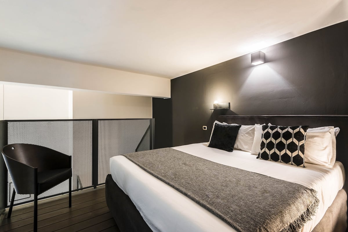 Ein modernes Hotelzimmer mit einem großen Bett, einem Sessel und einem Balkon.