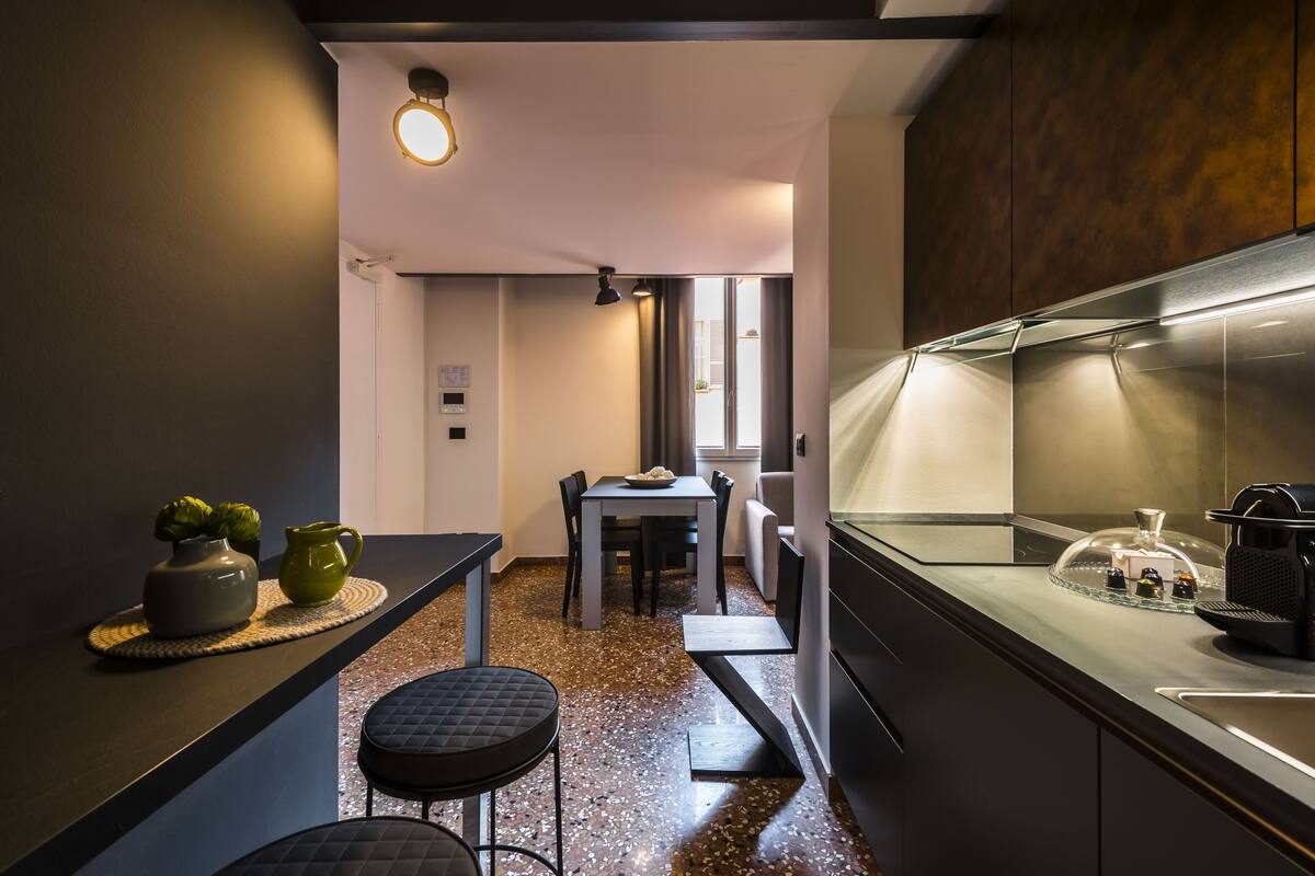 Eine moderne Küche mit Essbereich, Granit-Arbeitsplatten und einer Edelstahl-Dunstabzugshaube.