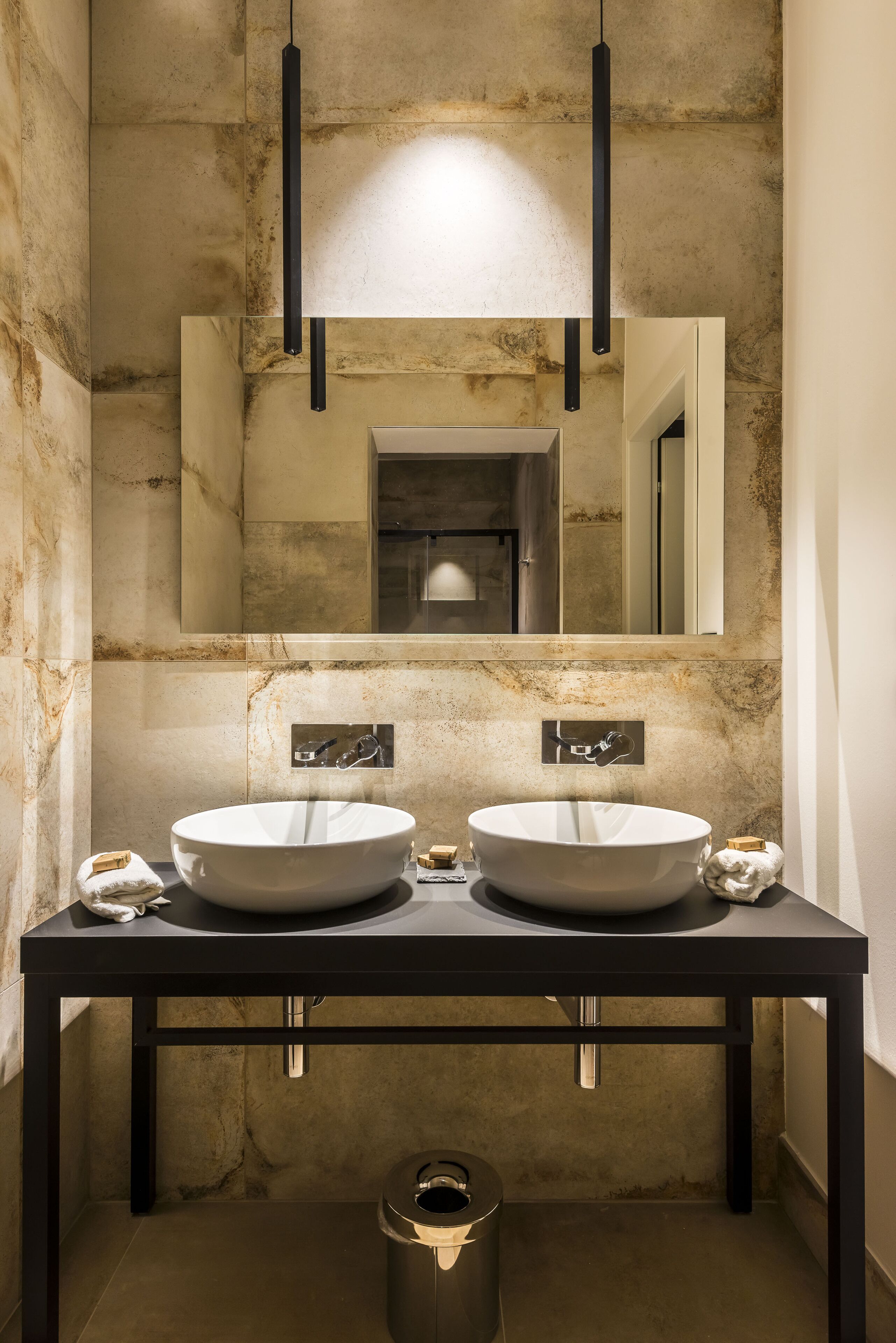 A bathroom with two sinks, a large mirror, and a modern design.