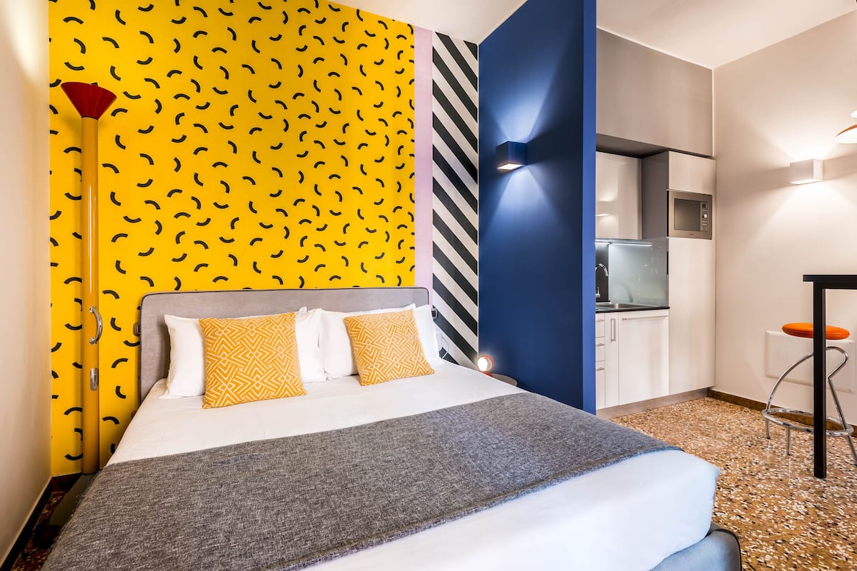 Ein modernes Hotelzimmer mit Bett, einer Küchenzeile und einem Badezimmer.