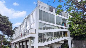 A modern hotel with a white facade, large windows, and a staircase leading to the entrance. - Terra Cassa Hotel (Bandungan)