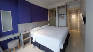 A modern hotel room with a bed, bedside table, and a small stool. - Terra Cassa Hotel (Bandungan)