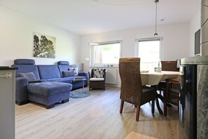 Una sala de estar con sofá, sillas, una mesa de comedor y una chimenea.