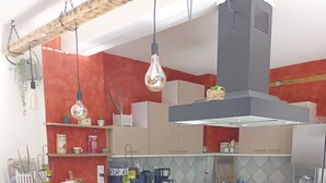 A modern kitchen with a wooden island, white chairs, and a built-in bench.
