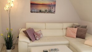 A modern living room with a white sofa, a coffee table, and a floor lamp. - Apartment sea breeze (Aventoft)