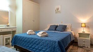 Una camera da letto con un letto, comodini, un armadio e una lampada a parete.